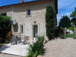 a stone house with two chairs and an umbrella at La Serva in Les Lèches