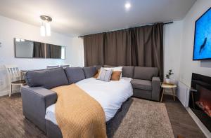a bedroom with a bed and a couch and a tv at RendezView by Revelstoke Vacations in Revelstoke