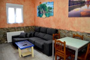 een woonkamer met een bank en een tafel bij Casa el Susurro in Villamediana de Iregua