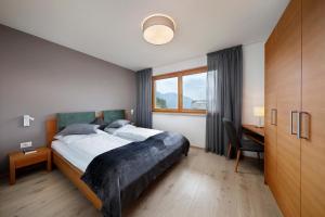 una camera con letto, scrivania e finestra di Schlettererhof a Tirolo