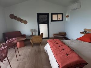 a bedroom with a bed and a couch and a chair at La lagune aux oiseaux in Palavas-les-Flots