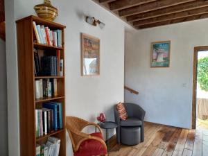 a living room with a book shelf and a chair at La lagune aux oiseaux in Palavas-les-Flots