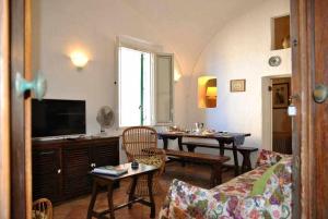 een woonkamer met een tafel en een televisie bij CASA CECILIA nel centro storico di Sperlonga in Sperlonga