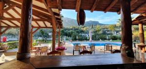 un restaurante con mesa y sillas y vistas a la piscina en Phivos Hotel, en Paleokastritsa