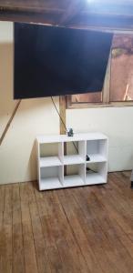 a white book shelf in a room with a tv at Cabaña los Naranjos con parqueo in Calarcá