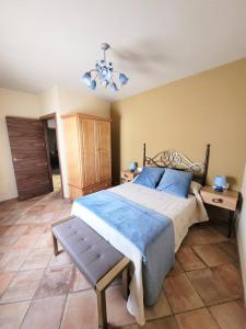 a bedroom with a large bed and a chandelier at CASA RURAL SANTA AGUEDA in Jaraba