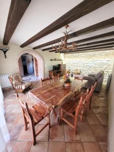 CASA RURAL SANTA AGUEDA في خارابا: غرفة معيشة مع طاولة وكراسي خشبية