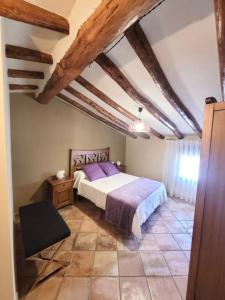 CASA RURAL SANTA AGUEDA في خارابا: غرفة نوم مع سرير كبير مع ملاءات أرجوانية