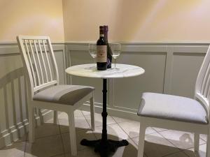 a bottle of wine sitting on a table with two chairs at Casa di Stefano in Rome