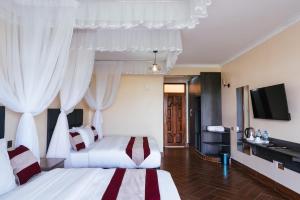 a hotel room with two beds and a flat screen tv at Olsupat Lodge in Nairobi