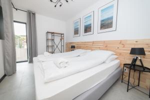 ポラニツァ・ズドルイにあるMS-APART Apartament Wood&Sauna Ogrody Pieniawskieの白いベッドルーム(白いシーツを使用した大型ベッド1台付)
