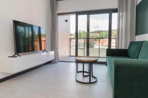 Televízia a/alebo spoločenská miestnosť v ubytovaní MS-APART Apartament Wood&Sauna Ogrody Pieniawskie