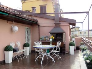 een patio met een tafel en stoelen en een open haard bij Montegrappa Apartment in Bologna