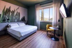 um quarto com uma cama, uma mesa e uma janela em Hotel Del Lago Piediluco Active & SPA em Piediluco