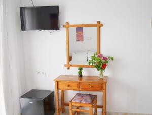 a table with a mirror and a television on a wall at Mak Luxury Rooms in Parga