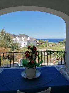 una mesa con un jarrón con flores en el balcón en villa Eolo, en Lipari