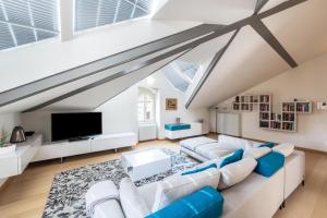 a living room with a white couch and a tv at Il Golfo Attico Vista Lago in Toscolano Maderno