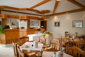 a restaurant with tables and chairs and a kitchen at Pension Christine in Großweikersdorf