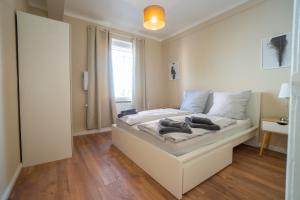 a white bed in a room with a window at "Creamlovers" Super Zentrale Ferienwohnung HBF-Messe-Buergerweide-CityGate-OVB Arena in Bremen