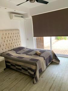 a bedroom with a bed and a large window at Elegant Villa in Grand Baie with Pool in Grand Baie