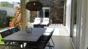 a wooden table and chairs on a patio with a table and a light at Elegant Villa in Grand Baie with Pool in Grand Baie