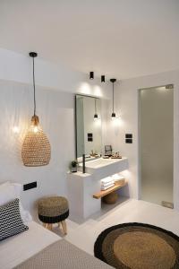 a bedroom with a bathroom with a sink and a mirror at Ios Art Studios & Luxury Apartments in Ios Chora