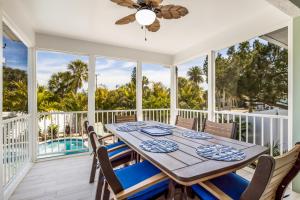 a dining room with a table and chairs on a balcony at Royal Palm: Pool, 2 Blocks to Beach, Close to Dining & Shopping by Anna Maria Life Vacation Rentals in Holmes Beach