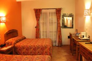 a hotel room with two beds and a desk at Hotel Casa Conzatti in Oaxaca City +22 photos