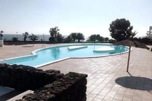 uma grande piscina num resort com acean em TUSCAN Apartment mit Meerblick und Sonnenterrasse em Costa Teguise