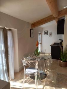een eetkamer met een glazen tafel en stoelen bij Le Mas Joséphine in Saint-Rémy-de-Provence