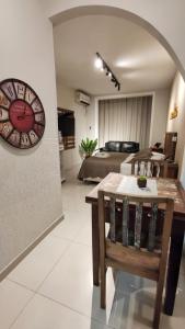a living room with a table and a clock on the wall at Baixo Copa Guest House in Rio de Janeiro