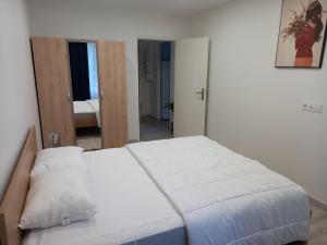 sypialnia z dużym łóżkiem z białą pościelą w obiekcie Appartement Standing Cœur d'Annecy w Annecy
