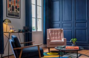 een woonkamer met blauwe muren en een stoel en een tafel bij Casa Mila & SPA- Chambres d'Hôtes raffinées vue Loire et piscine in Saint-Mathurin