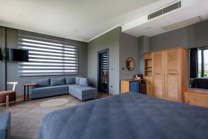 sypialnia z niebieskim łóżkiem i kanapą w obiekcie Petrion Hotel w Stambule