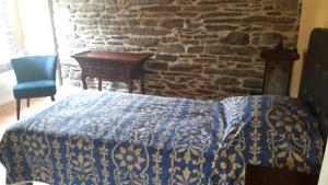 a bedroom with a bed and a stone wall at Le cocon in Cherbourg en Cotentin