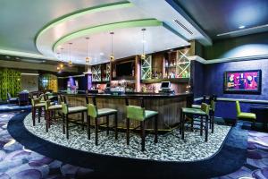 a bar in a hotel room with chairs and a counter at La Quinta Inn & Suites by Wyndham San Antonio Riverwalk in San Antonio