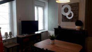 a living room with a table and a television at Le cocon in Cherbourg en Cotentin