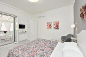 biała sypialnia z łóżkiem i stołem w obiekcie B&B inCentro w mieście Santa Maria di Castellabate