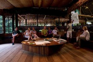 un grupo de personas sentadas alrededor de una mesa en una habitación en Tapir Lodge, en Marian