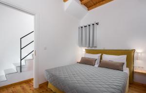 een slaapkamer met een bed in een kamer met een trap bij Horizon Villas in Agios Ioannis