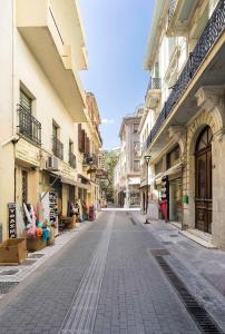 an empty street in a city with buildings at La Maison Athenes in Athens