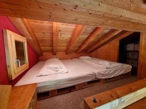 a bed in a room in a wooden house at Cute attic apartment in the heart of the mountains in Münster