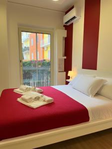 uma cama com um cobertor vermelho e uma janela em Pompei Art em Scafati