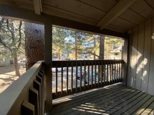 un porche de una casa con barandilla de madera en Mammoth Awesome Location-1 min to Shuttles & Food en Mammoth Lakes