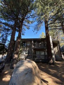 a large rock in front of a house with trees at Mammoth Awesome Location-1 min to Shuttles & Food in Mammoth Lakes