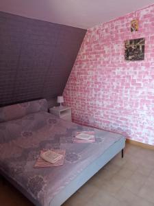 a bedroom with a pink brick wall and a bed at Appartamento Via Mancini in Scalea