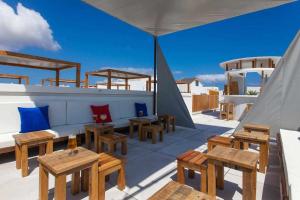a rooftop patio with wooden tables and benches at Hotel Vacanzy Urban Boutique Adults Only in Corralejo