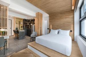 a bedroom with a white bed and a kitchen at La Maison Athenes in Athens