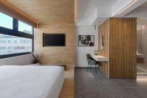 a bedroom with a bed and a desk and a tv at La Maison Athenes in Athens