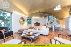 a living room with a couch and a table at SolHabitat Villa Maroa in Benissa